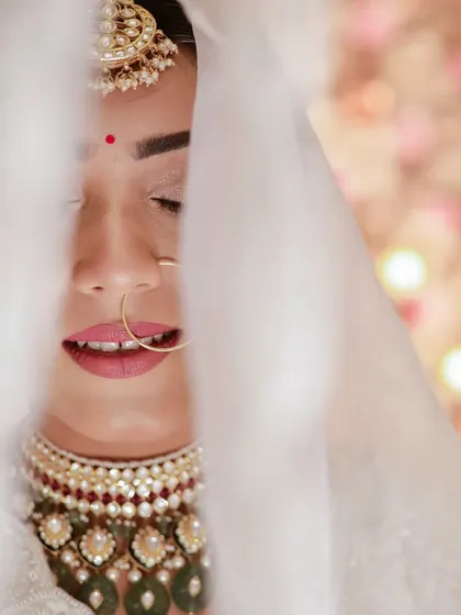 Another beautiful close-up through the veil, focusing on the bride's expression and her gorgeous jewelry.