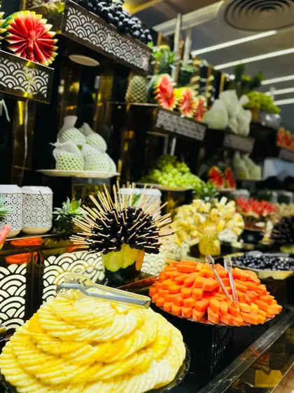 A close-up of an artistic fruit display, with sliced pineapple, papaya, and watermelon.