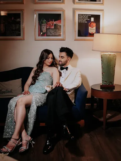 An intimate portrait of a couple during their cocktail party. The warm, moody lighting of the lounge and their stylish attire create a sophisticated and romantic atmosphere.