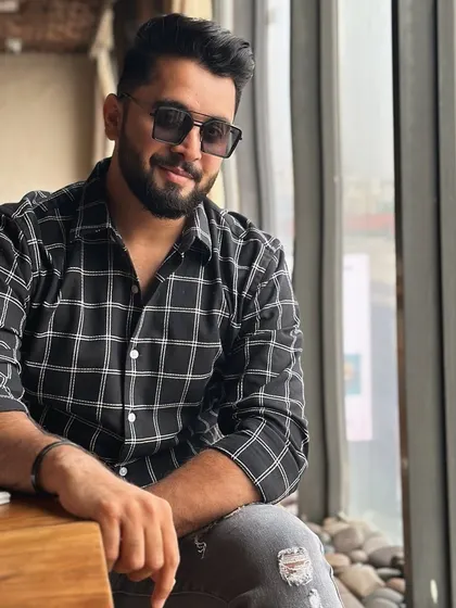 Even my casual style is on point. Here I am in a checkered shirt, taking a moment to relax. My off-duty look is as important as my on-duty one.