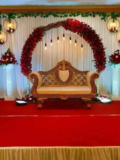 We design stunning stages for your most important moments. This engagement setup features a dramatic circular arch of red roses, elegant hanging lights, and a classic diwan, creating a rich and romantic focal point for your celebration.