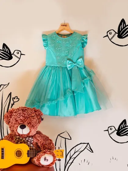 This turquoise dress is ready for its moment. Paired with a teddy bear and guitar, it shows that even the most elegant dresses are made for fun and imagination.