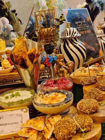 A close-up of our Mezze Platter section within a larger grazing table. We offer a variety of fresh dips like hummus and beetroot, served alongside falafel and pita bread for an authentic Lebanese flavor.