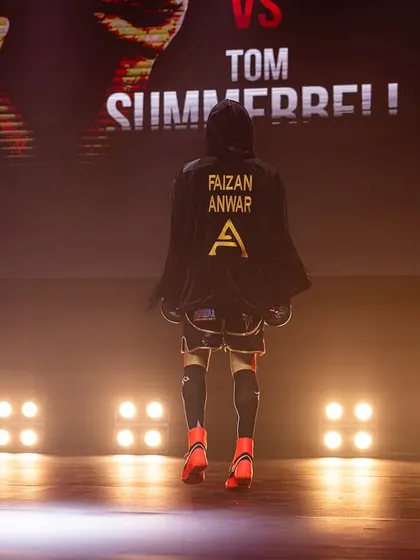 A dramatic ring walk, the fighter emerging from the shadows and into the spotlight.