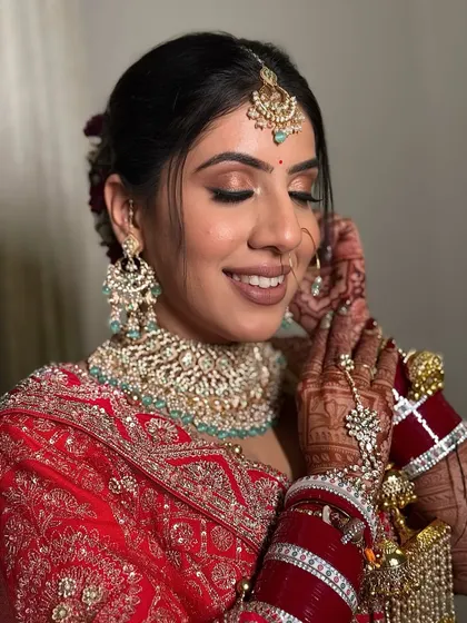 Adjusting her earring, this bride looks absolutely radiant. The makeup is designed to be flawless up close, with a smooth base and beautifully blended eyeshadow.