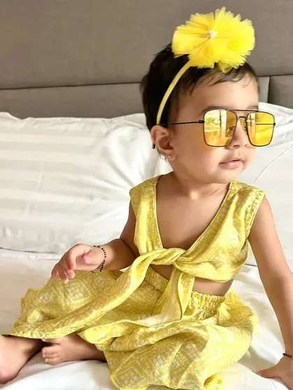 This little fashionista is rocking a custom yellow tie-front co-ord set. It's a chic and breezy outfit perfect for a stylish day out or a summer vacation.