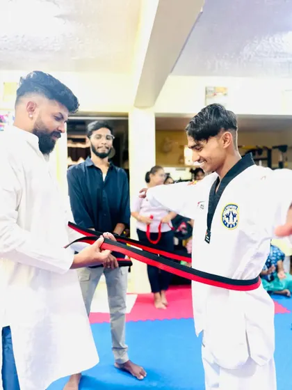 A student receives his red and black belt, the final step before becoming a black belt.