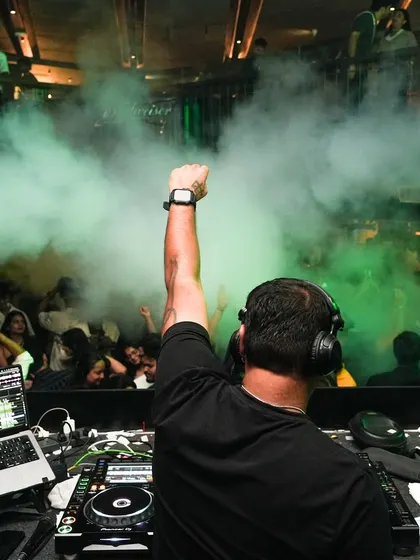 The view from my console is the best in the house. This shot captures that moment of connection with a packed floor, fist in the air, right before the beat drops. It's all about channeling that collective energy.