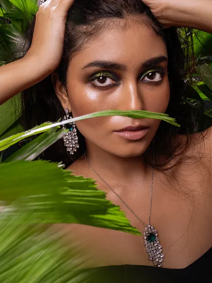 A direct and powerful gaze, where the dramatic eye makeup and sparkling jewellery create a captivating image.