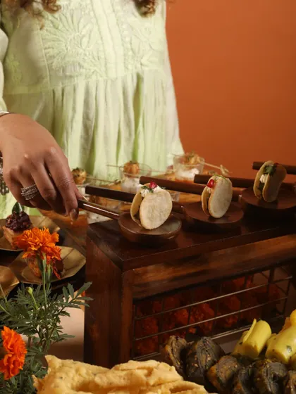 A server arranging mini tacos on a wooden serving stand. This behind-the-scenes shot shows the care and attention that goes into every detail of our food setup, ensuring a perfect presentation.