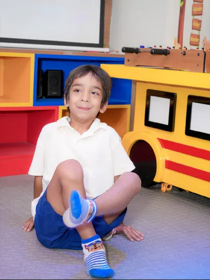 A young boy relaxes on the floor after an exciting time in the play area.