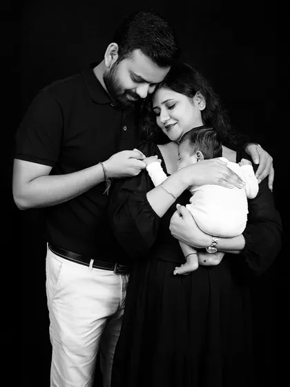 A bond beyond words. This black and white portrait of a new family is filled with emotion, capturing the love and awe as they hold their newborn baby.