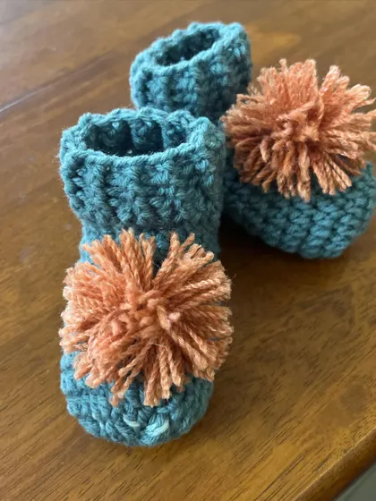 I just love making matching sets! These are the baby booties with fluffy orange pom-poms that go with the beanie. They are so cute and make a wonderful gift for a baby shower.