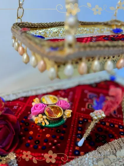 A close-up of our Krishna jhula, focusing on the decorated base with a mini tilak platter and tilak stick. Every element is thoughtfully placed to honor the auspicious occasion of Janmashtami.