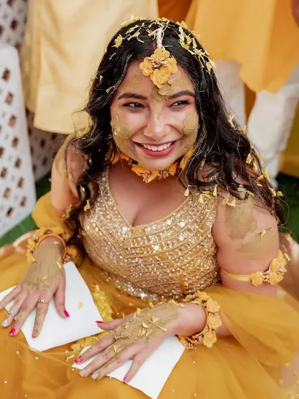 The bride's joyful expression after being 'Haldified' by her loved ones. These are the priceless, candid moments that tell the real story of your wedding.