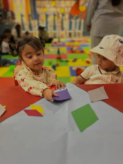 Two toddlers at our Rajouri Garden center work side-by-side on a kite craft, an early lesson in parallel play and social awareness.
