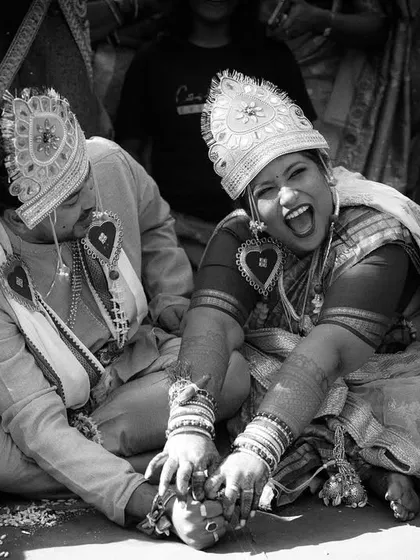 A moment of pure, unrestrained laughter during a traditional Odia wedding game. This black and white candid shot is full of life and shows the fun side of wedding rituals.