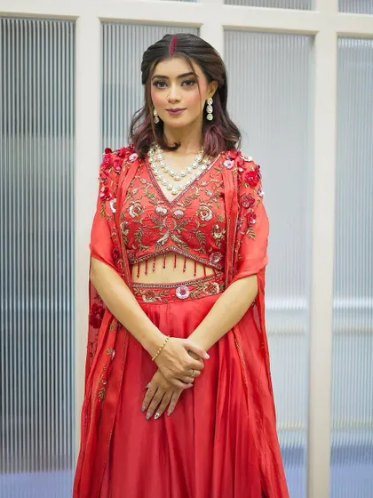 A full-length view of our client's Karva Chauth outfit and makeup. The soft, romantic makeup look is the perfect complement to her flowing red dress and pearl necklace.