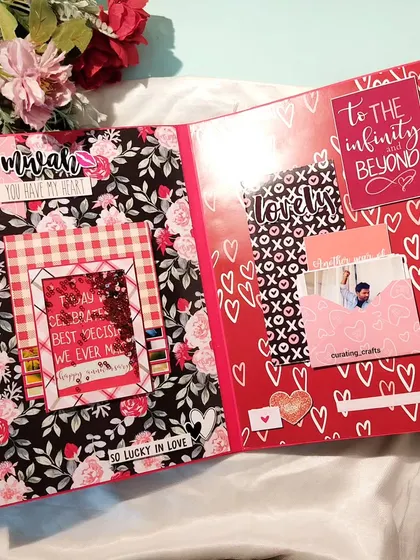 This page from the anniversary scrapbook uses a bold red and black floral theme. It includes a shaker frame and a mini envelope for a secret message, adding interactive elements to the album.