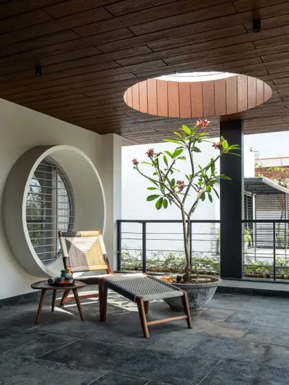 This covered terrace extends the living area outdoors, providing a comfortable space for siesta, complete with a circular skylight and a view of the garden.