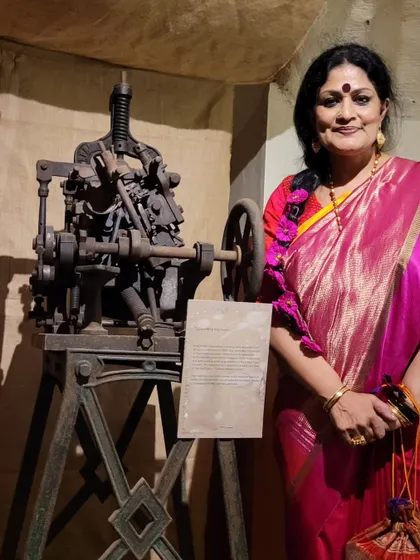 Posing with one of the antique manual printing presses at the HARAF Exhibition, a tangible link to the history of Bengali typography.