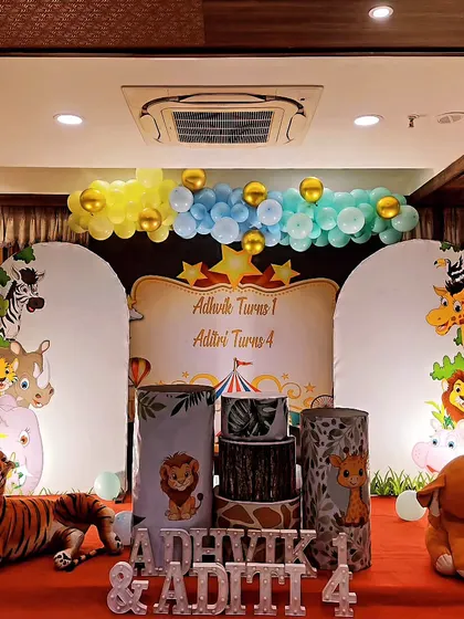 This jungle theme party was for two siblings. I created a symmetrical design with two backdrop panels featuring different animals, connected by a balloon garland. Themed cake stands and a large tiger prop completed the scene.