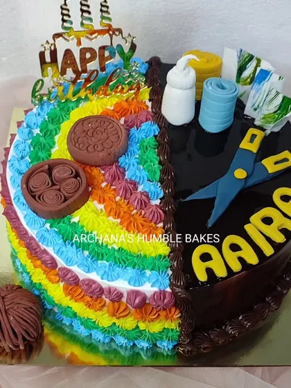A half-and-half cake celebrating a love for both art and craft. One side is a colorful rainbow, and the other is a rich chocolate design with craft-themed toppers.