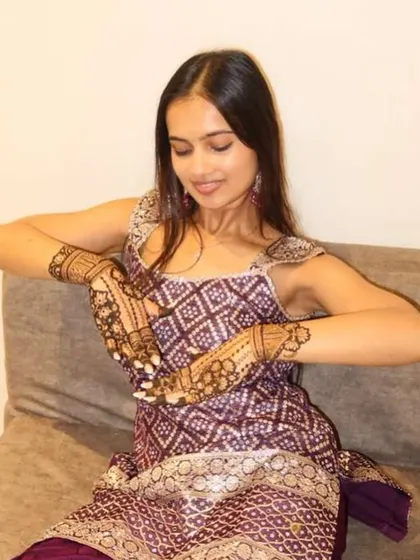 The groom's sister looking radiant as she shows off her beautiful henna design.