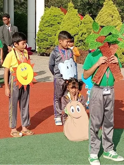 The narrator explains the science behind seed germination while other students act out the roles of a tree, the sun, and a cloud.