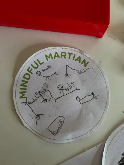 The kids earned their "Mindful Martian" badges! This camper carefully drew all the yoga poses they learned, a wonderful way to reinforce the day's lessons through art.