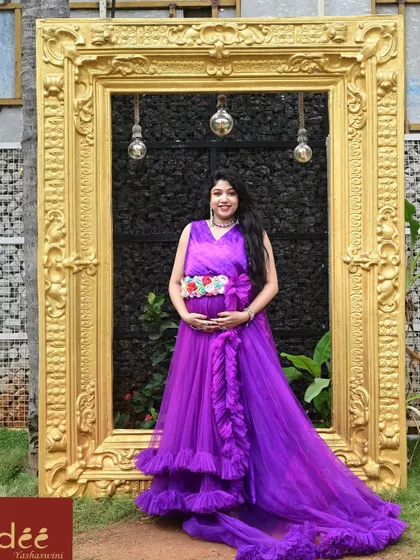 Framed perfectly. A client poses in our purple ruffle maternity gown, a popular rental choice for its vibrant color and beautiful design.