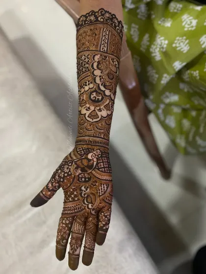 A single-hand view of a detailed bridal design. This showcases the fine line work and the combination of different patterns to create a cohesive piece.