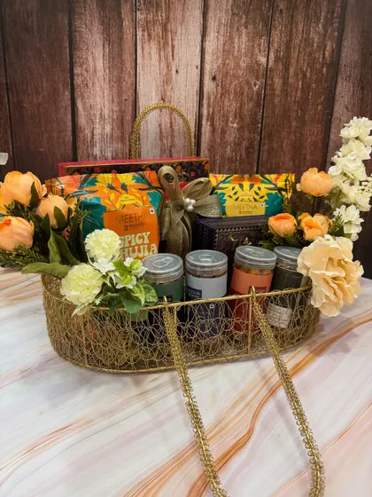 This large, boat-shaped wire basket is perfect for a big family to share on Rakhi. It's packed with a wide assortment of savory snacks and sweets, and decorated with peach-colored flowers.
