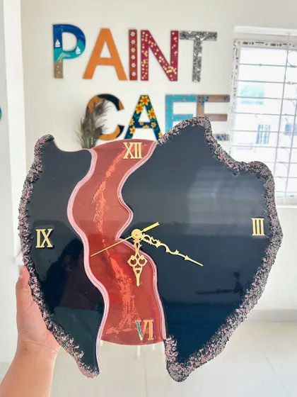 A bold, abstract geode clock with a river of red and pink flowing through a black background.