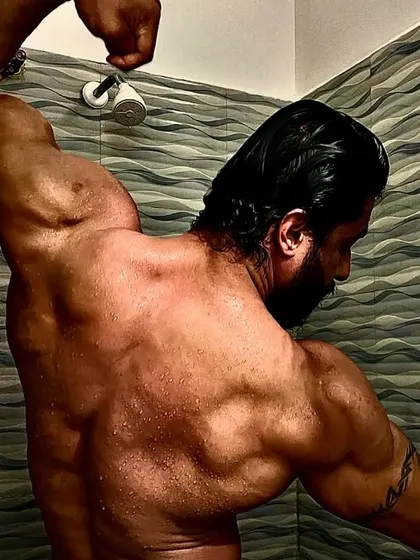 A one-arm back pose, highlighting the separation between my lats, traps, and rear delts.
