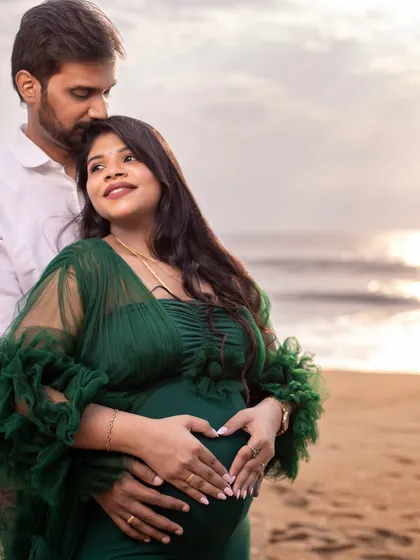 A heart-shaped gesture over the bump, with the ocean in the background. A classic and beloved maternity pose that we capture with an artistic touch.
