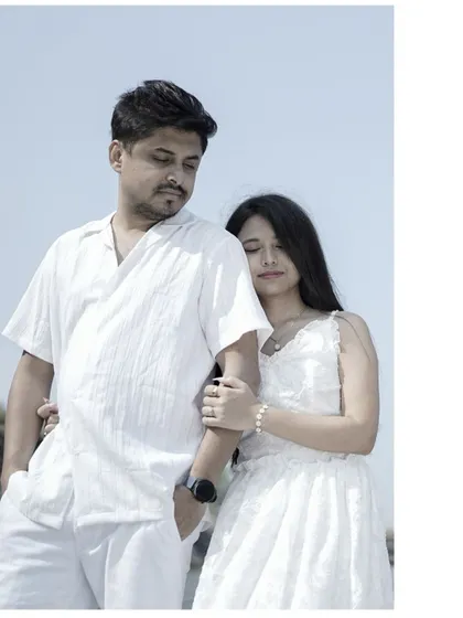 A romantic portrait of a couple in white, with the bride resting her head on the groom's arm.