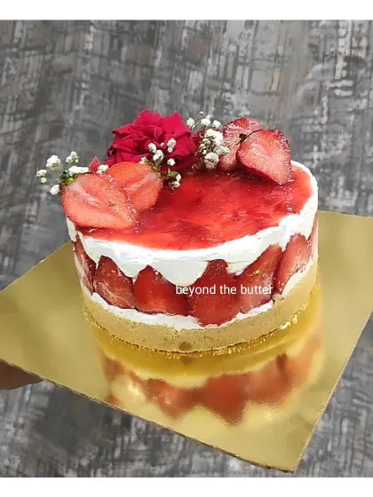A beautiful strawberry cheesecake with a biscuit crust, creamy filling, and a topping of fresh strawberries and glaze.