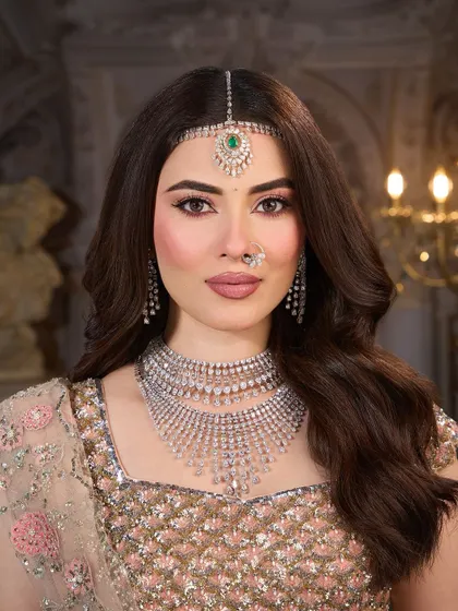 A close up on the soft, romantic makeup. The eyes are defined with a gentle winged liner and the skin is given a luminous, pearlescent glow.