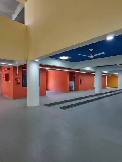 The interior parking and entrance area of the Ankleshwar skill development center, where the interior color scheme of red, yellow, and blue reflects the building's exterior architectural theme.