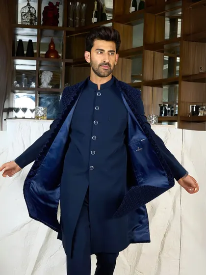 The navy Indo-Western jacket is opened to reveal the rich satin lining and the sleek kurta underneath. This shows the quality of construction, inside and out.