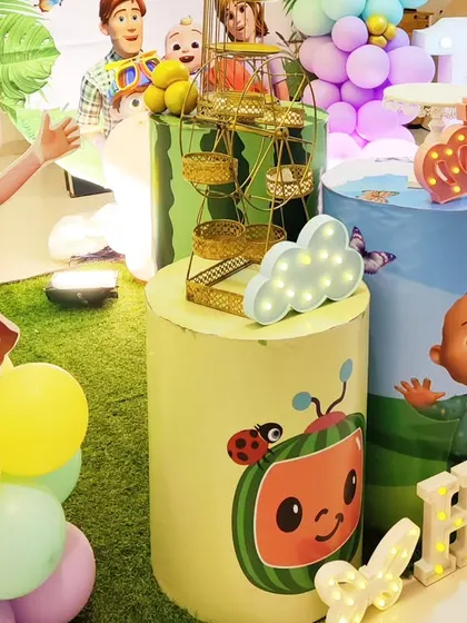 A close-up of Cocomelon-themed dessert plinths, featuring character prints and a mini ferris wheel.