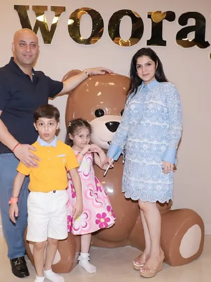 A family poses with our giant teddy bear, a favorite photo spot for guests.