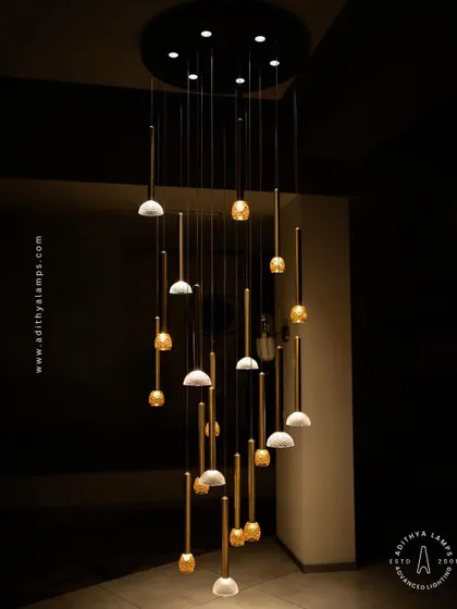 This cluster pendant features a mix of gold-toned rods with textured glass shades, some resembling pineapples and others simple domes. The combination creates a visually interesting and warm installation for any corner that needs a lift.
