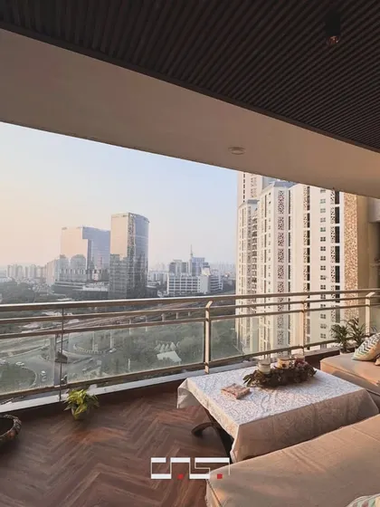 A stunning view over the city from the balcony lounge. The comfortable sofa is perfect for relaxing and taking in the expansive urban landscape.
