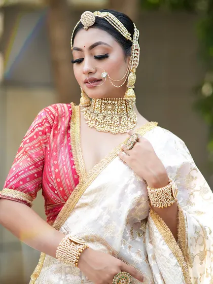 The soft elegance of this minimal bridal look. The makeup is focused on flawless skin and defined eyes, allowing the intricate jewelry to take center stage.