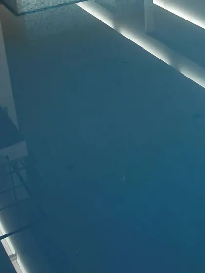 The calm surface of the indoor pool reflecting the architectural lines and light from above.