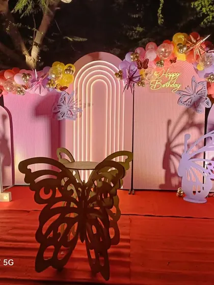 A closer look at the butterfly birthday stage. You can see the details like the marquee number "1" and the intricate laser-cut butterfly props.