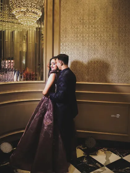 A sophisticated portrait of the couple in a warm, richly decorated room. The reflection in the mirror adds depth and an artistic touch to the composition.