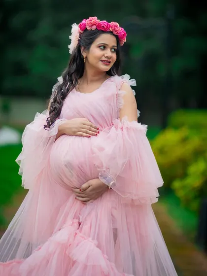 A close-up portrait showcasing the intricate details of this pink ruffled gown and the radiant glow of the mom-to-be. Professional makeup is included to make you feel your best.